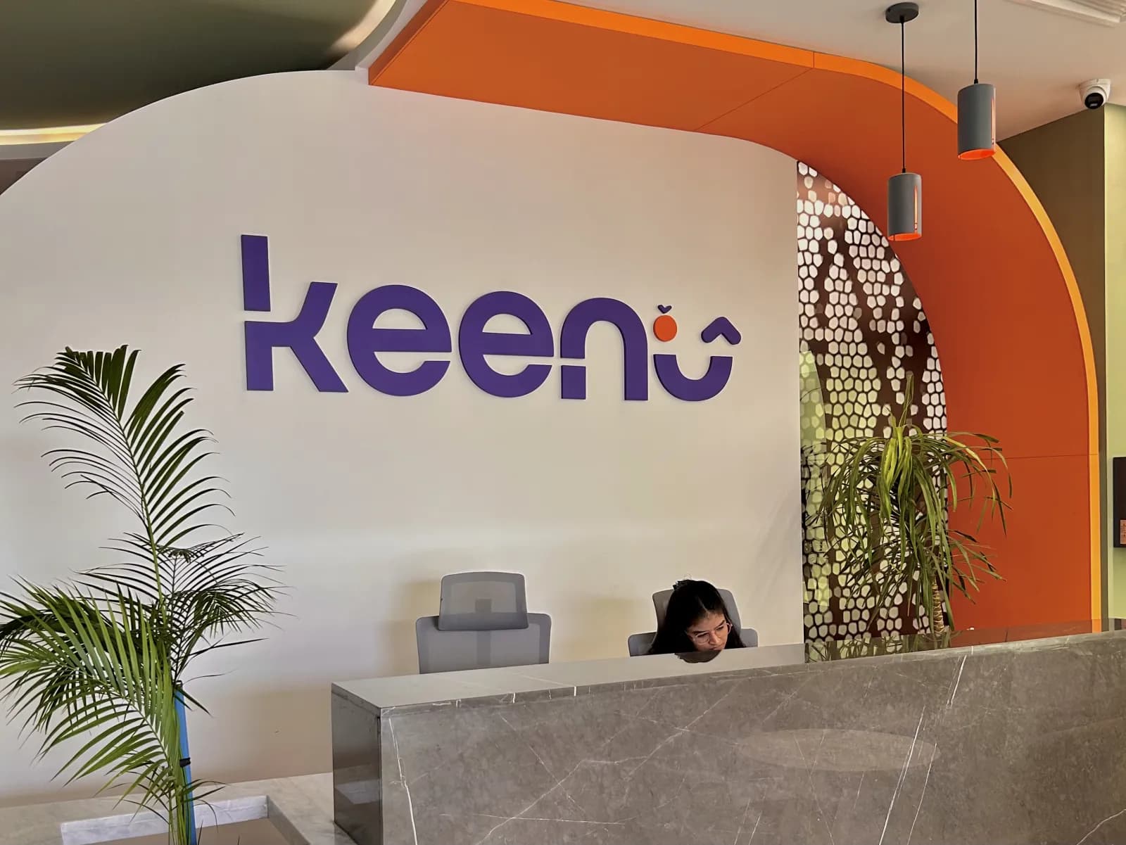 Keenu office reception with the brand wall