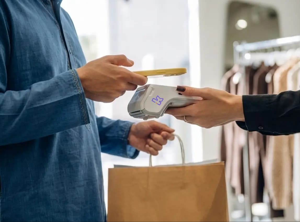 Customer tapping a card on a Keenu terminal at a fashion store counter