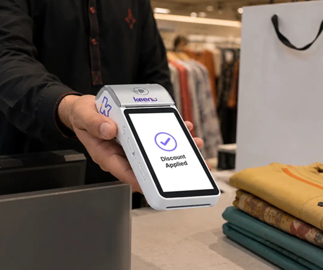 Handheld Keenu terminal showing a Discount Applied screen at a clothing store till